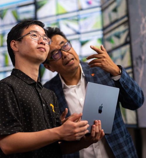 Professor Lee Han explains the application of his research involving crowdsourced traffic and road condition data to graduate students Yangsong Gu and Diyi Liu in a lab