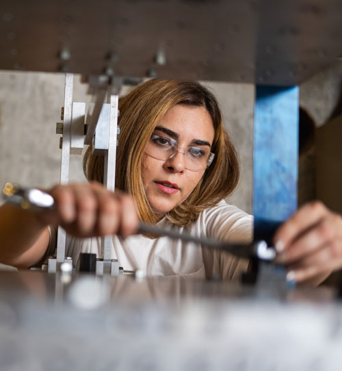 Doctoral student Sima Abolghasemi installs a structure on a 6 degrees-of-freedom shake table, which simulates an earthquake, in the high bay lab