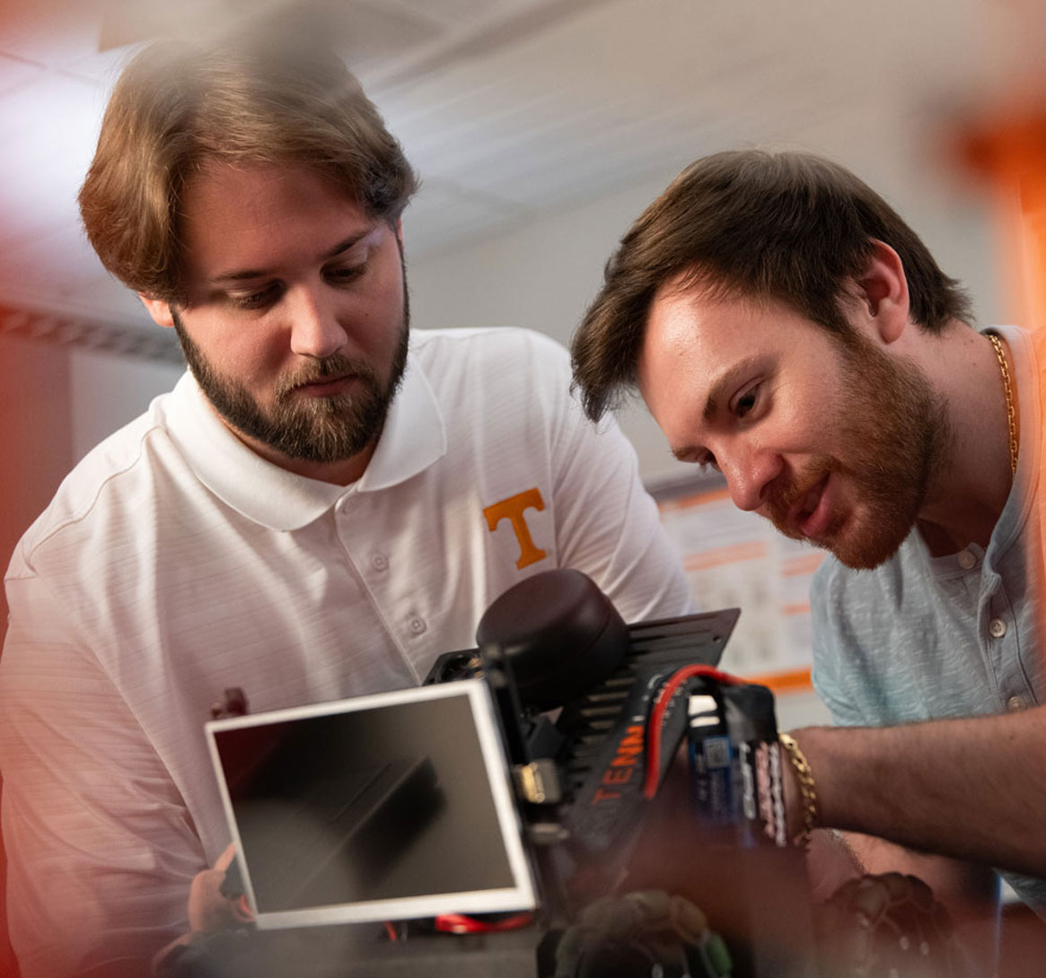 Graduate students Adam Foshie and Charles Rizzo work on autonomous vehicle GRANT (Ground Roaming Autonomous Neuromorphic Targeter) in a neuromorphic computing lab