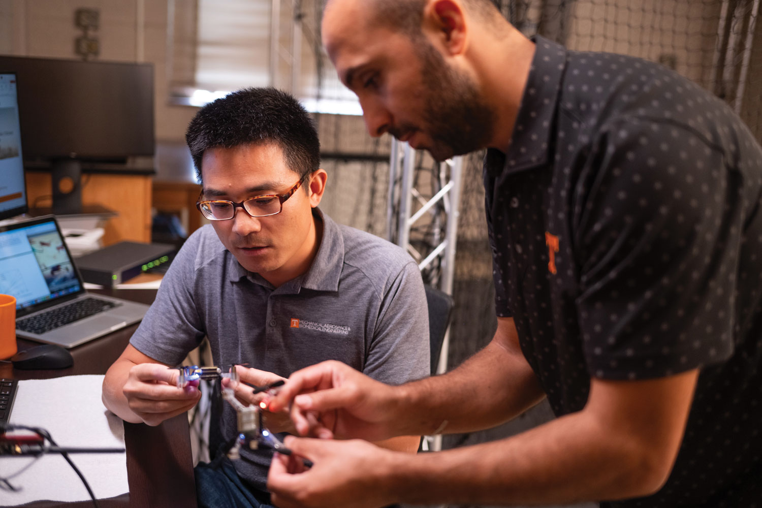 Zhenbo Wang and grad student work on assembling drone.