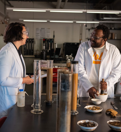 Lecturer Sarah Mobley guides graduate student Mohammed Elnur through testing soil samples using a hydrometer in a lab